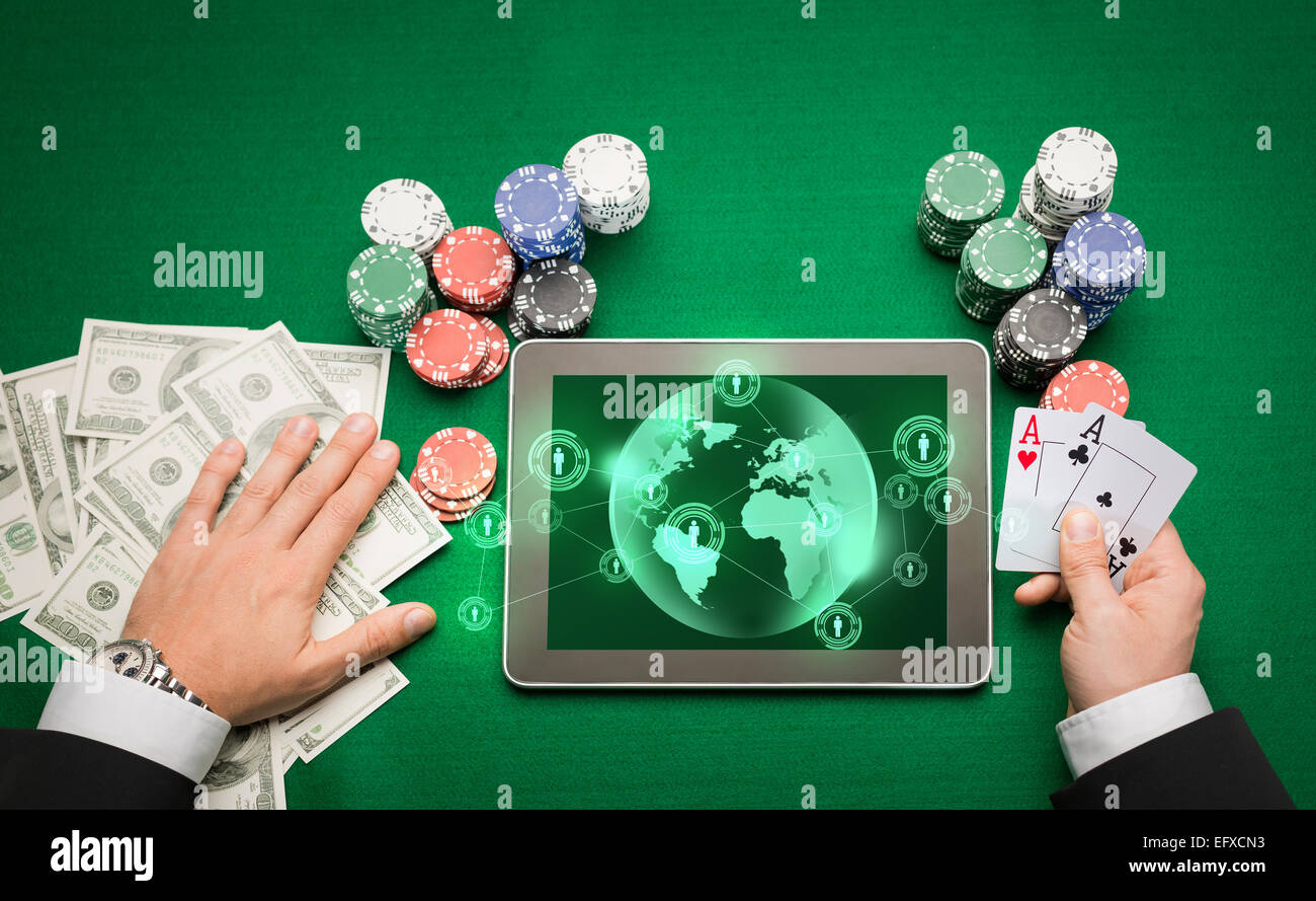 Casinò poker player con cards, tablet e trucioli Foto Stock