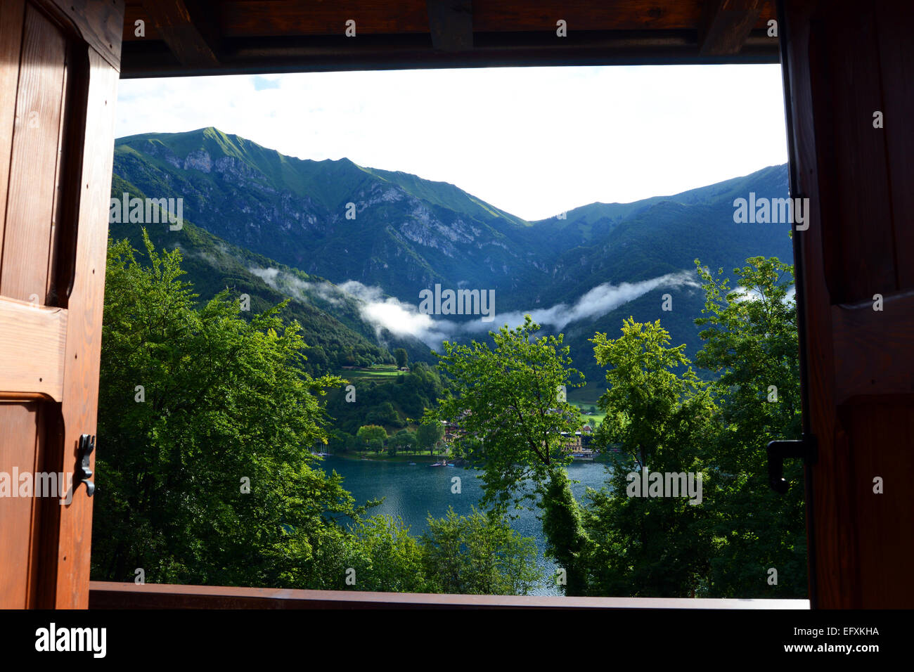 Montagna e lago vista da una casa vacanze finestra, Lago di Ledro, Dolomiti, Italia. Foto Stock