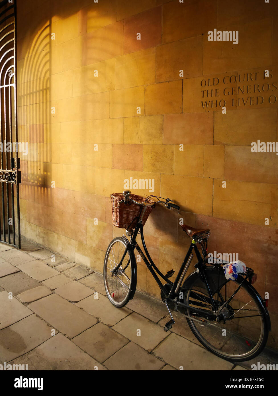 Bike appoggiato contro una parete, Università di Cambridge Foto Stock