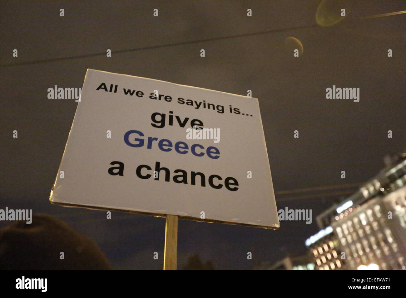 Atene, Grecia. Xi Febbraio, 2015. Un segno legge 'tutti stiamo dicendo è dare la Grecia una possibilità", un riferimento a una canzone dei Beatles "Date una possibilità alla pace". Migliaia di greci hanno protestato ad Atene in piazza Syntagma di fronte al parlamento greco a sostegno del governo greco in anticipo della cruciale Eurogruppo incontro che si intendono, per forzare la Grecia in una prosecuzione della politica di austerità. Credito: Michael Debets/Pacific Press/Alamy Live News Foto Stock