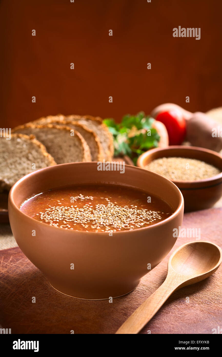 Crema di vegatable zuppa di pomodoro, carota, patata e prezzemolo e servite nella ciotola e cosparso di semi di sesamo Foto Stock