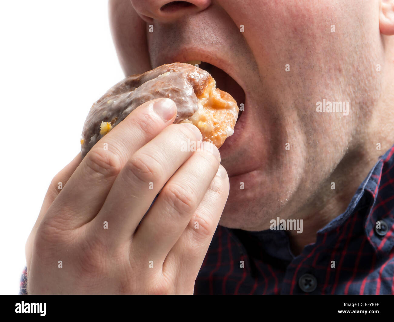 Side Shot dell'uomo mangiare ciambella shot su bianco Foto Stock