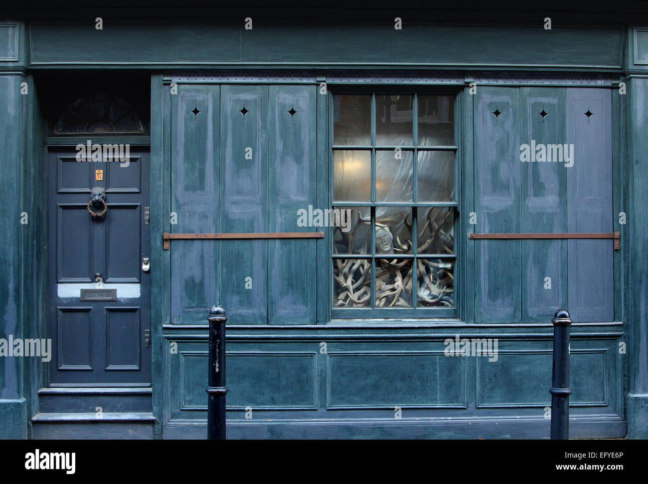 La testa di un manichino su un mucchio di corna di cervo sul display in London street finestra Foto Stock