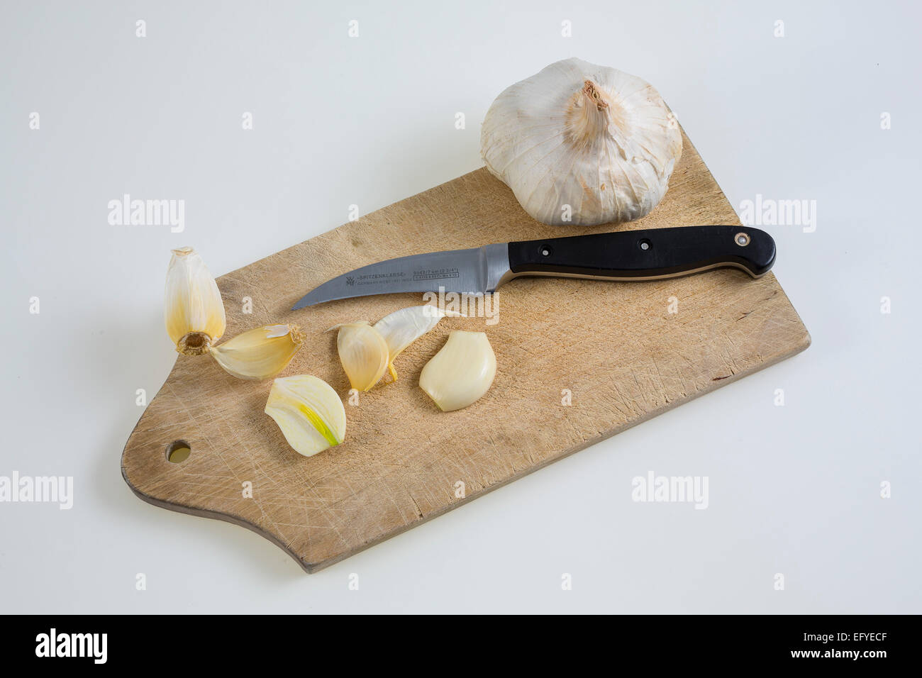 Knoblauch (Allium sativum) auf einem Küchenbrett mit Messer Foto Stock