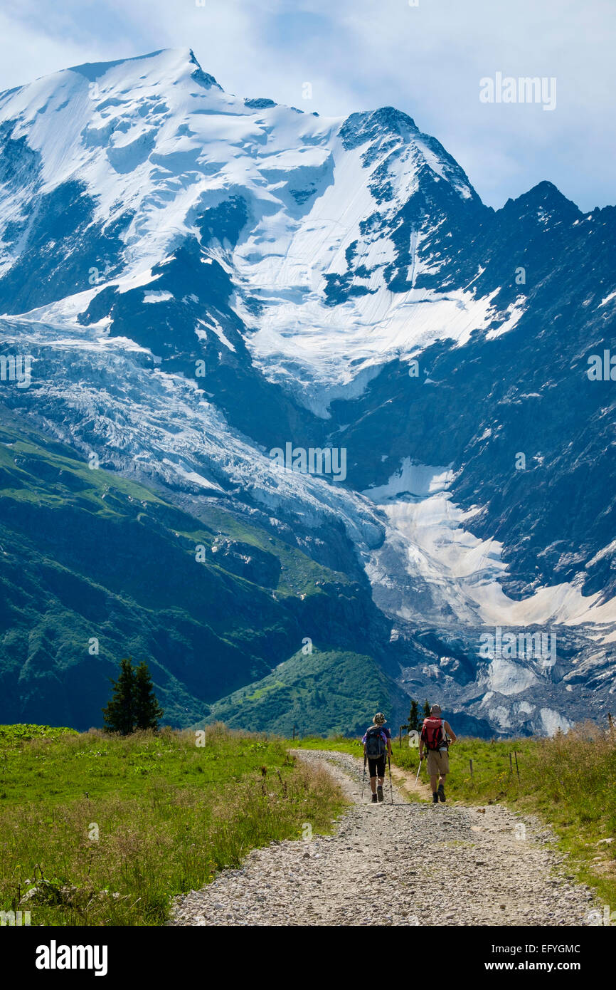 Walkers a Mont Blanc e il ghiacciaio de Bionnassay dietro, Rhone Alpes montagne, Chamonix Haute Savoie, sulle Alpi francesi, Francia Foto Stock