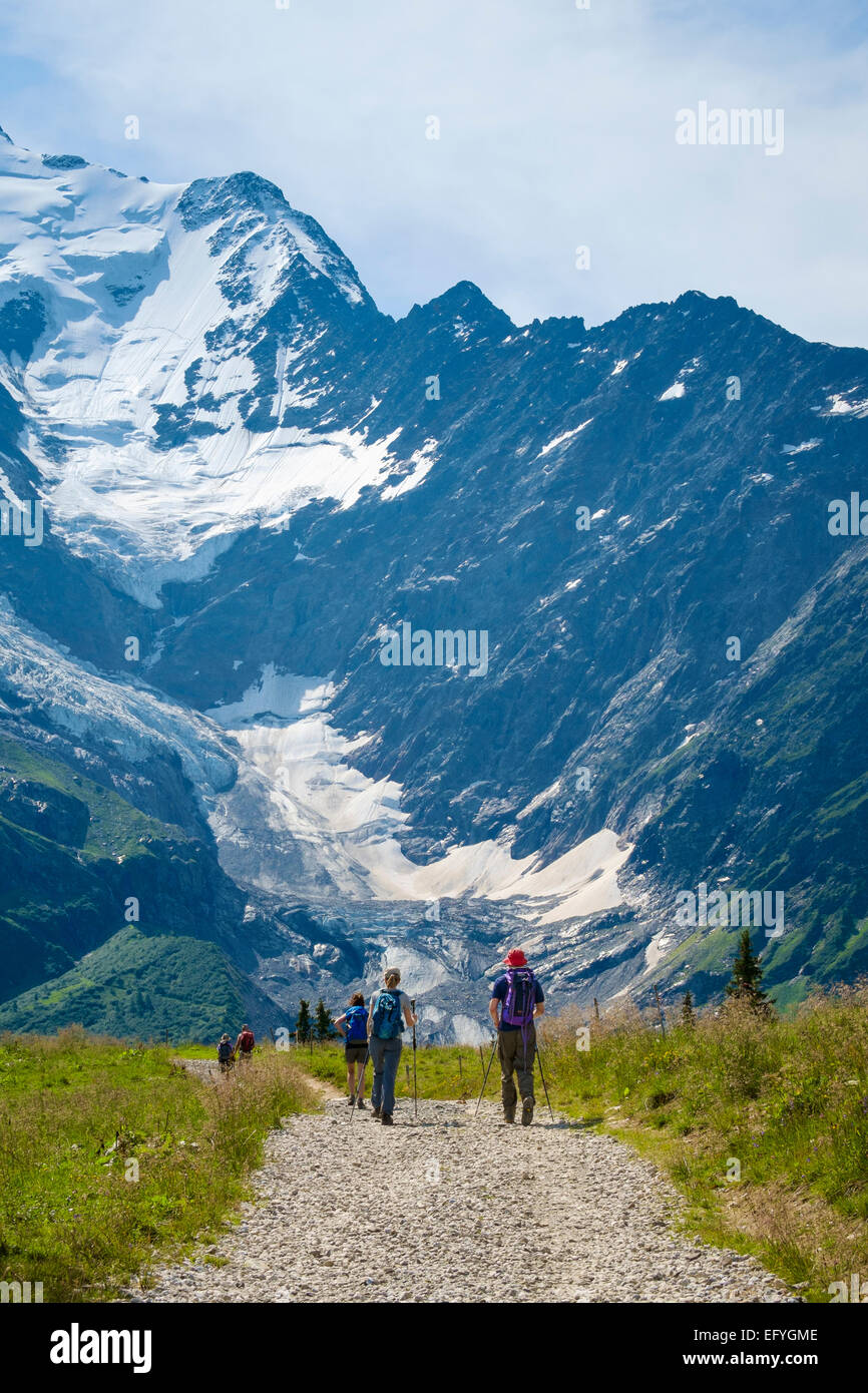 Le Alpi Francesi escursionisti escursionismo a piedi sotto il Monte Bianco e il ghiacciaio de Bionnassay, in Francia, in Europa in estate Foto Stock