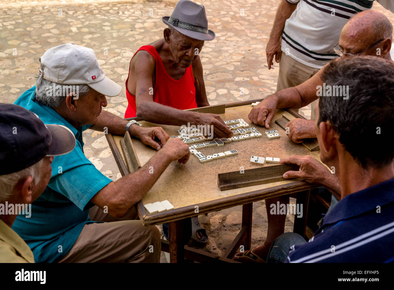Uomini cubano GIOCA Domino a un tavolo esterno, old town,Trinidad, Sancti Spiritus Provincia, Cuba Foto Stock