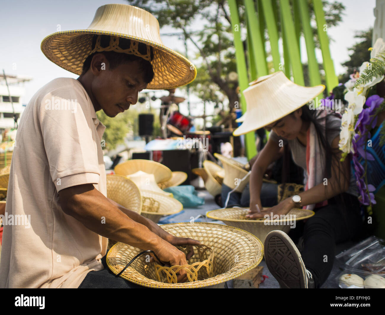 Bangkok, Bangkok, Thailandia. 12 Feb, 2015. Gli studenti fanno uno stile tradizionale Thai di cappelli di paglia al nuovo mercato galleggiante aperti in Khlong Phadung Krung Kasem, a 5,5 chilometro lungo canale scavato come un fossato attorno a Bangkok nel 1850s. Il mercato galleggiante aperto all'estremità nord del canal vicino al Palazzo del Governo, che è l'ufficio del Primo Ministro. Il mercato galleggiante era l idea del Primo ministro tailandese generale Prayuth Chan-OCHA. Il mercato sarà aperta fino al 1 marzo. © Jack Kurtz/ZUMA filo/Alamy Live News Foto Stock