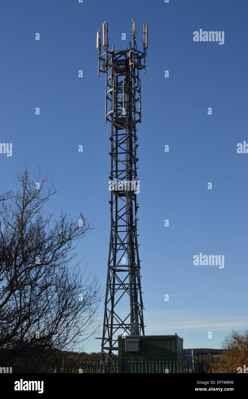 Telefono mobile montante, contro un luminoso cielo blu. Foto Stock