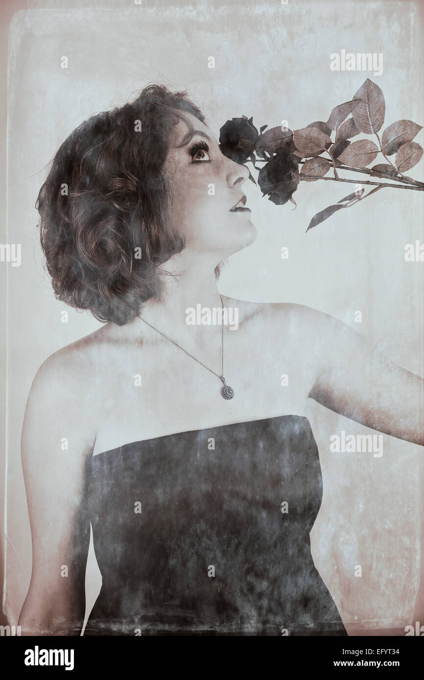 Immagine in bianco e nero del giovane e bella donna che indossa senza spalline vestaglia e azienda rose Foto Stock