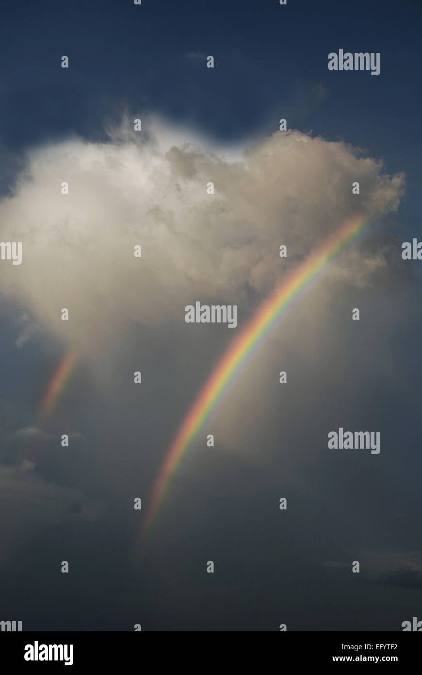Doppio arcobaleno emerge da una a forma di cuore il cloud Foto Stock