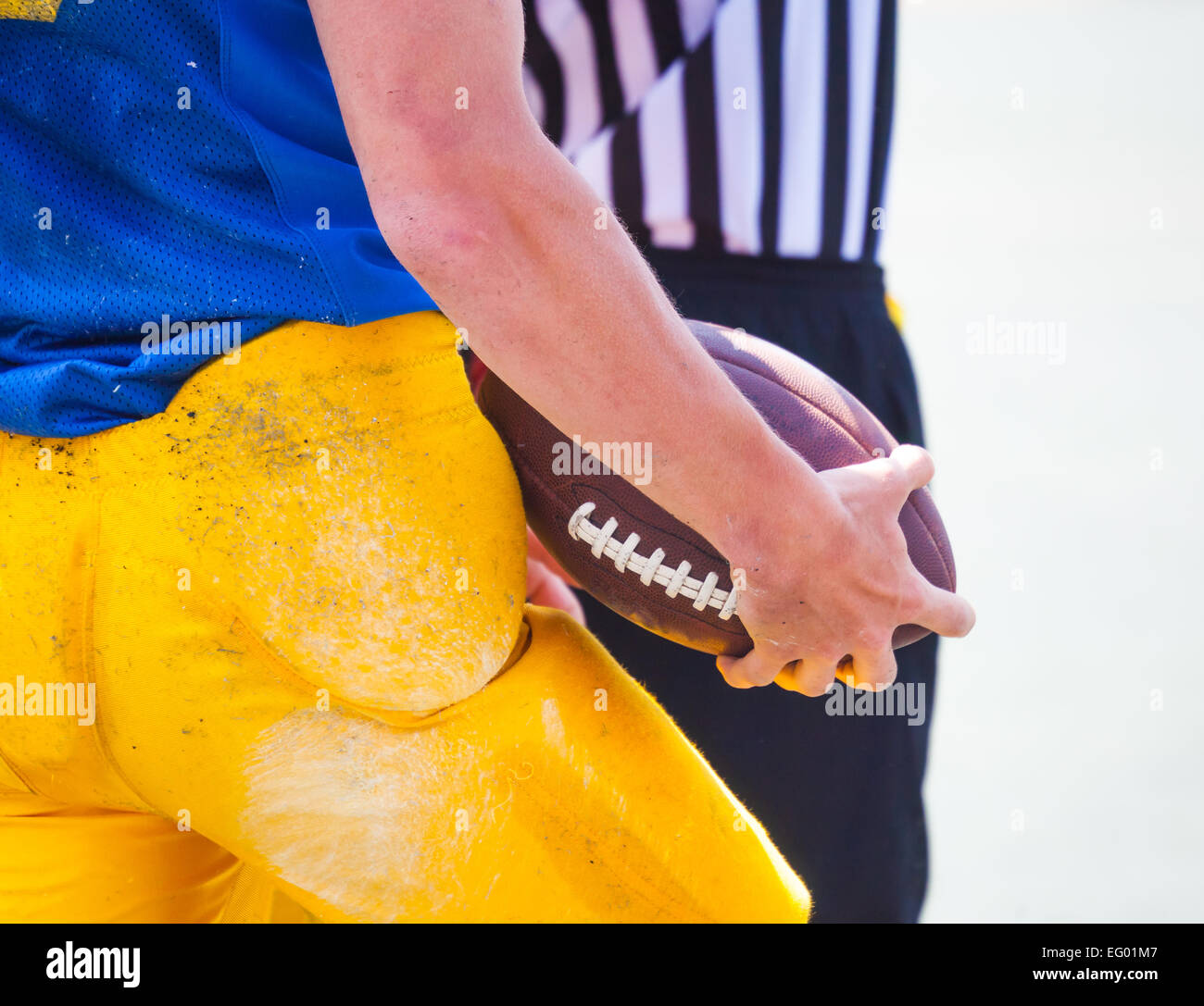 Sono arbitro e giocatore di football americano tenendo la palla nelle sue mani Foto Stock