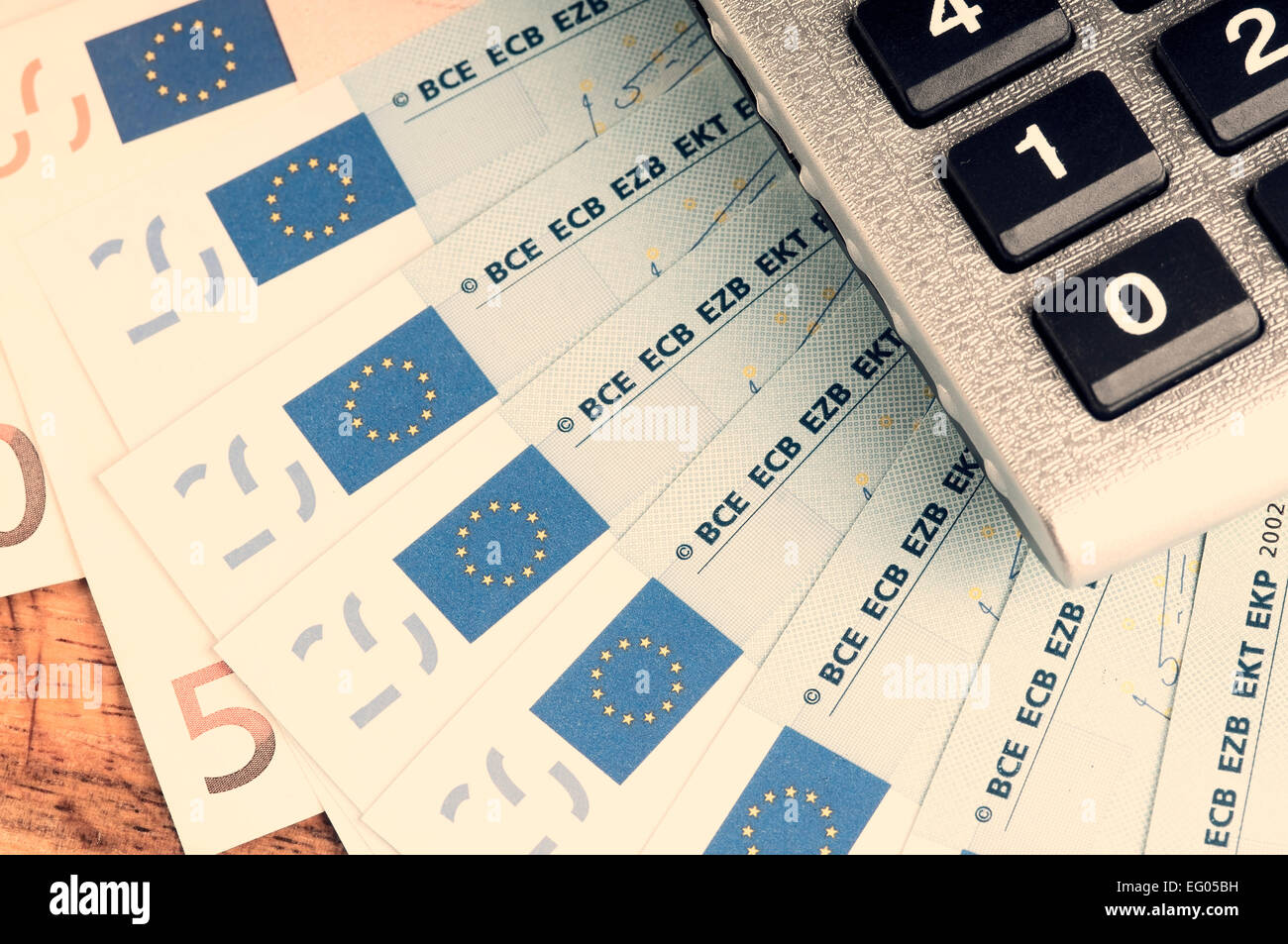 Il concetto di risparmio di denaro e calcolatrice su una tavola di legno con tonalità di colore in instagram effetto Foto Stock