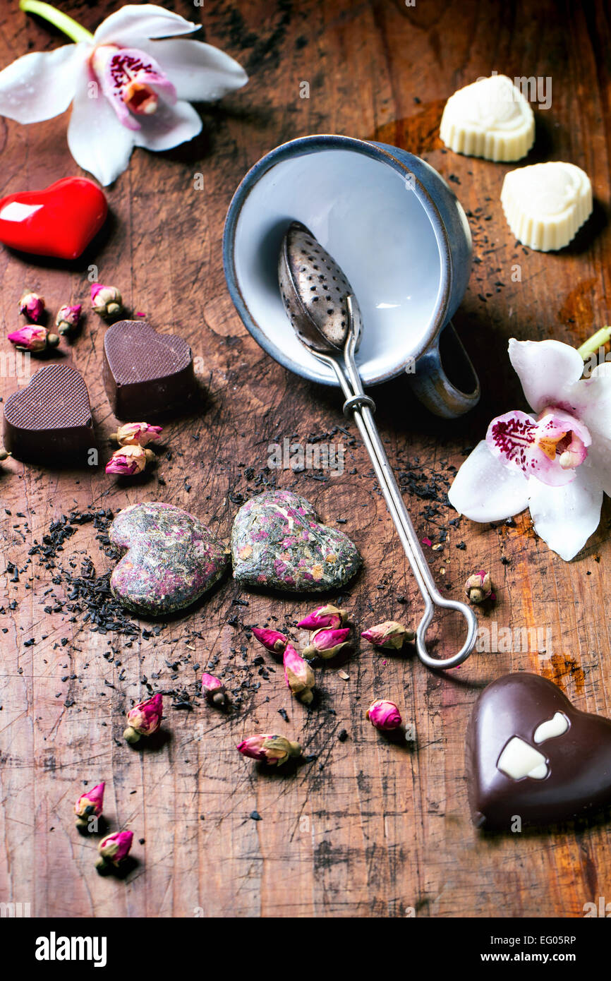 Cioccolatini a forma di cuore a secco con tea rose e tazza da tè per il giorno di San Valentino. Foto Stock