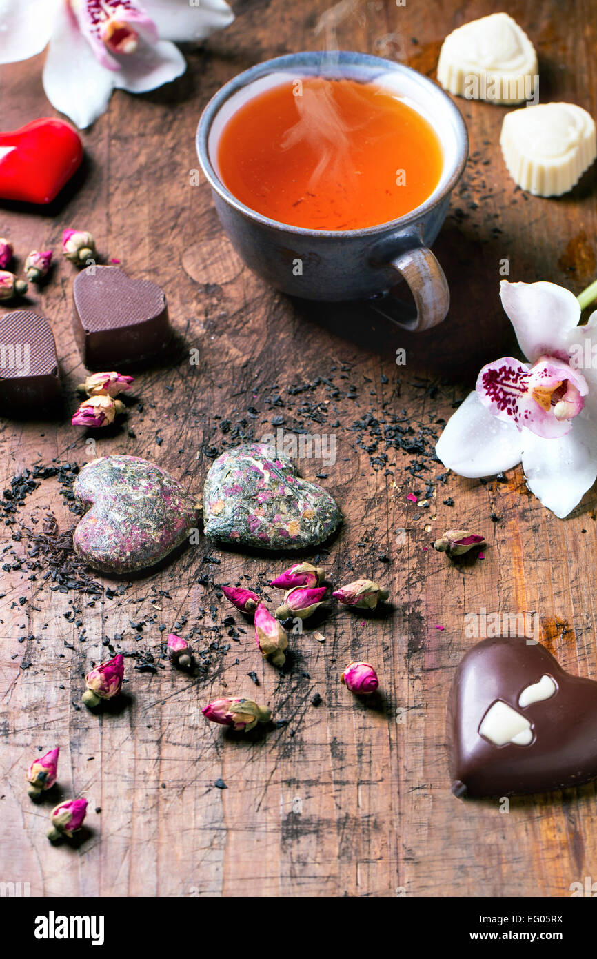 Cioccolatini a forma di cuore a secco con tea rose e tazza da tè per il giorno di San Valentino. Foto Stock