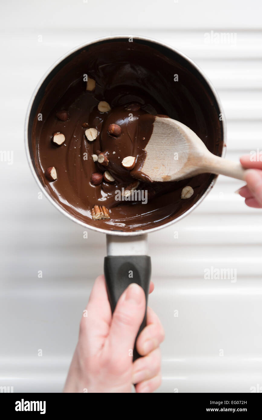 La cottura con il cioccolato fuso e il dado salsa in una pentola. Foto Stock