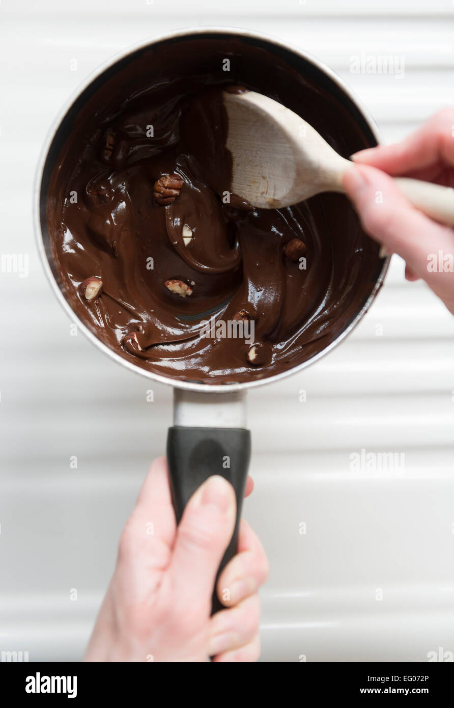 La cottura con il cioccolato fuso e il dado salsa in una pentola. Foto Stock