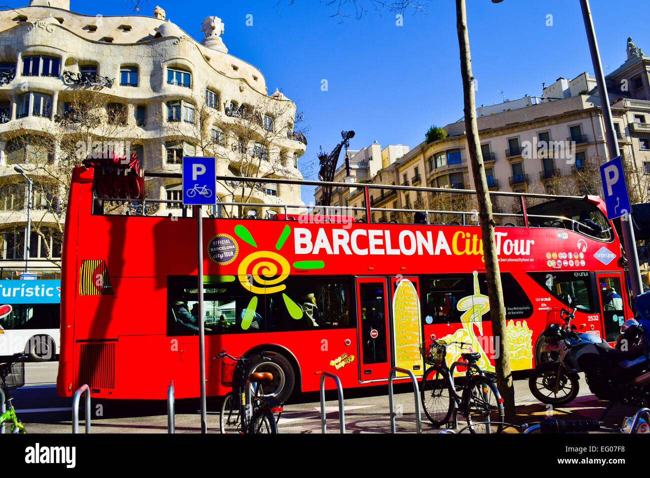 Barcelona city tour bus in una parte anteriore della Casa Mila aka La Pedrera progettato da Antoni Gaudi. Barcellona, in Catalogna, Spagna. Foto Stock
