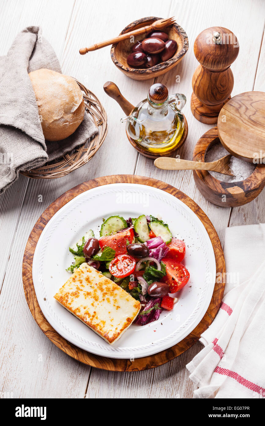 Verdura fresca insalata con formaggio alla griglia su bianco sullo sfondo di legno Foto Stock