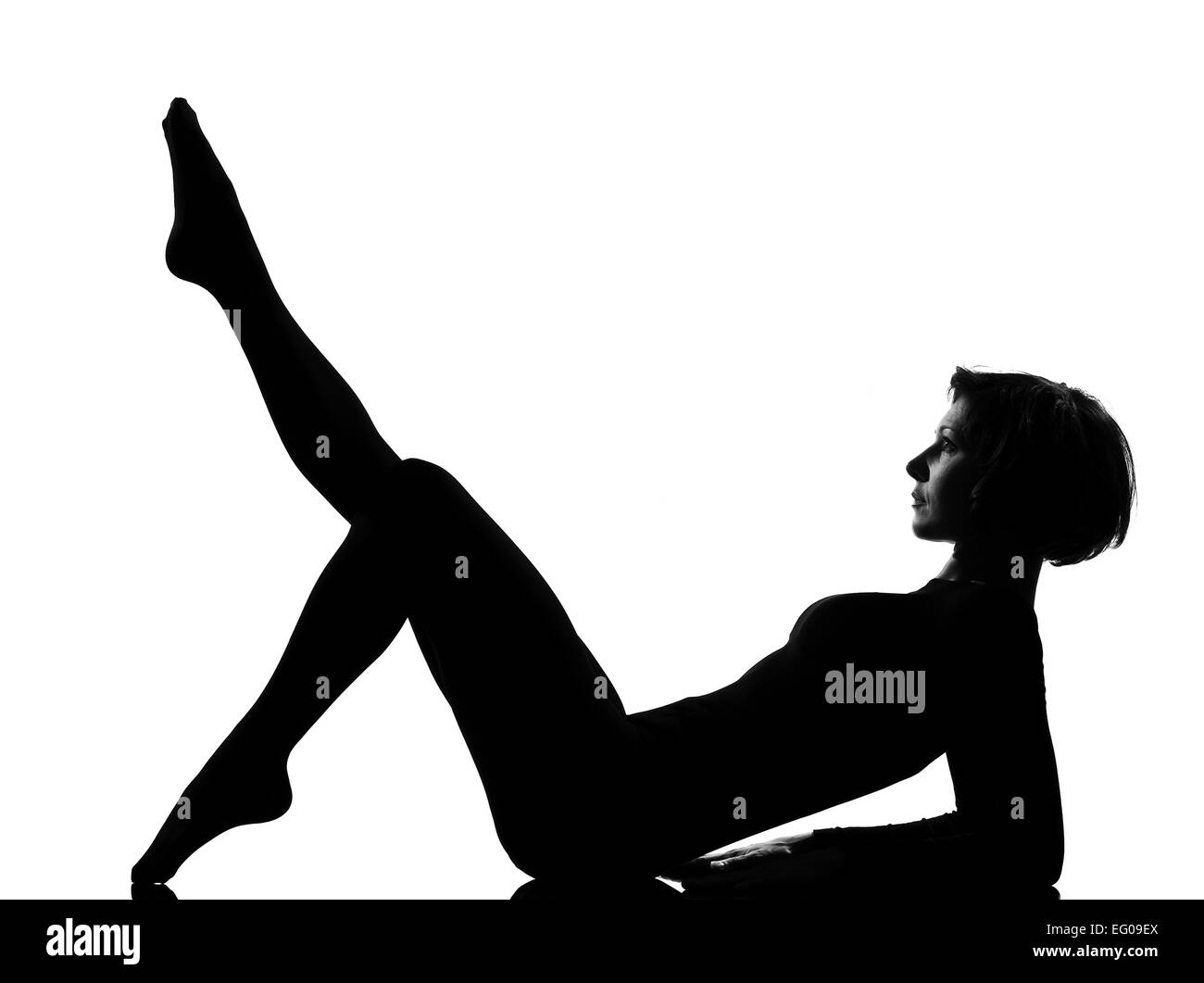 Donna che esercitano giacente sul retro fitness stretching yoga in ombra silhouette di scala di grigi per tutta la lunghezza in studio isolato sfondo bianco Foto Stock