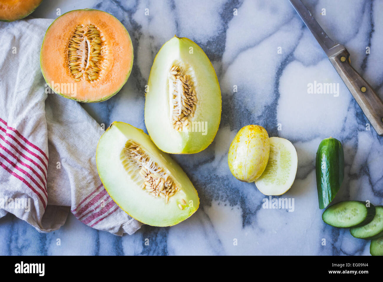 Cetrioli e meloni su una superficie di lavoro Foto Stock