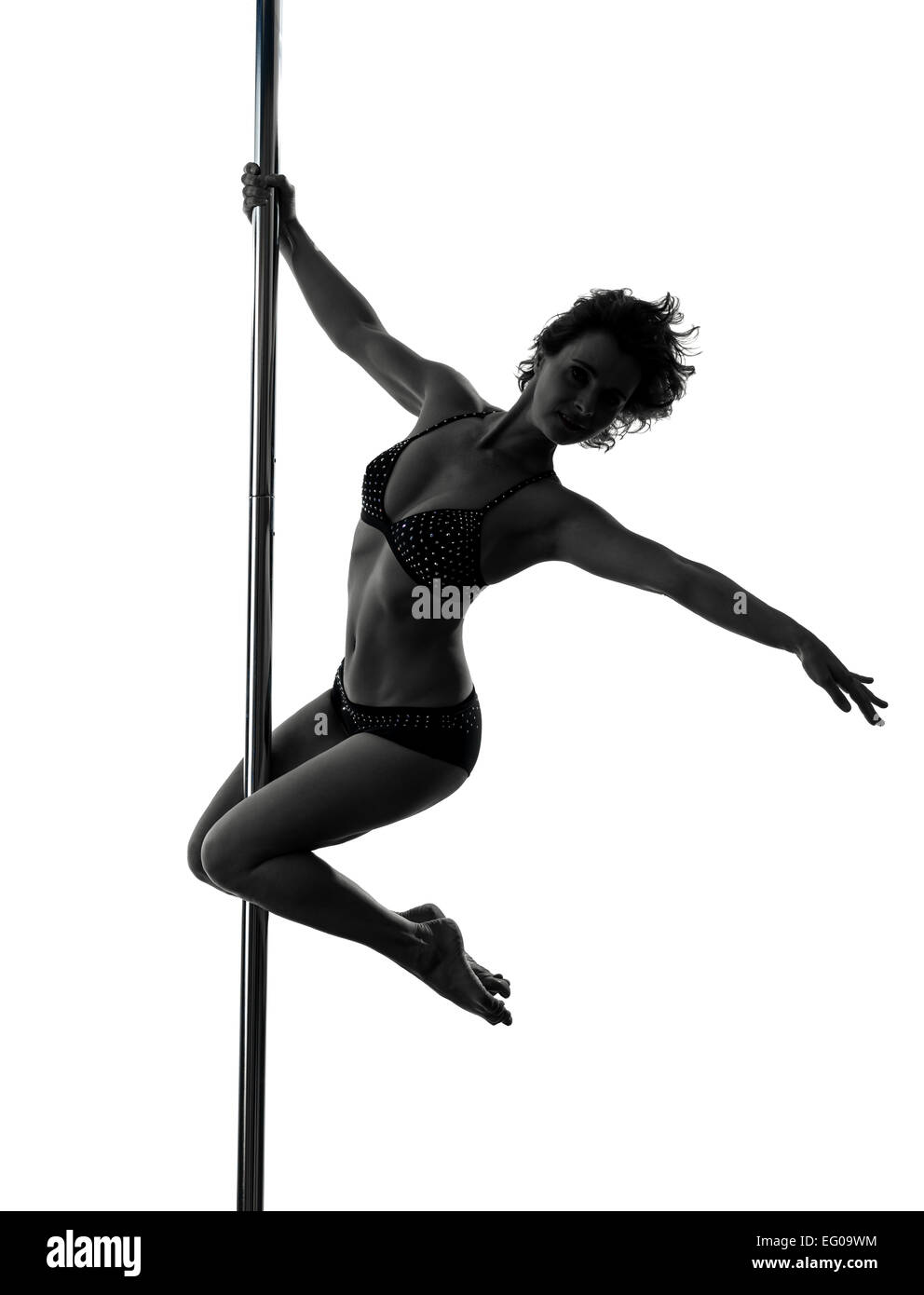 Una donna pole dancer dancing in silhouette studio isolato su sfondo bianco Foto Stock