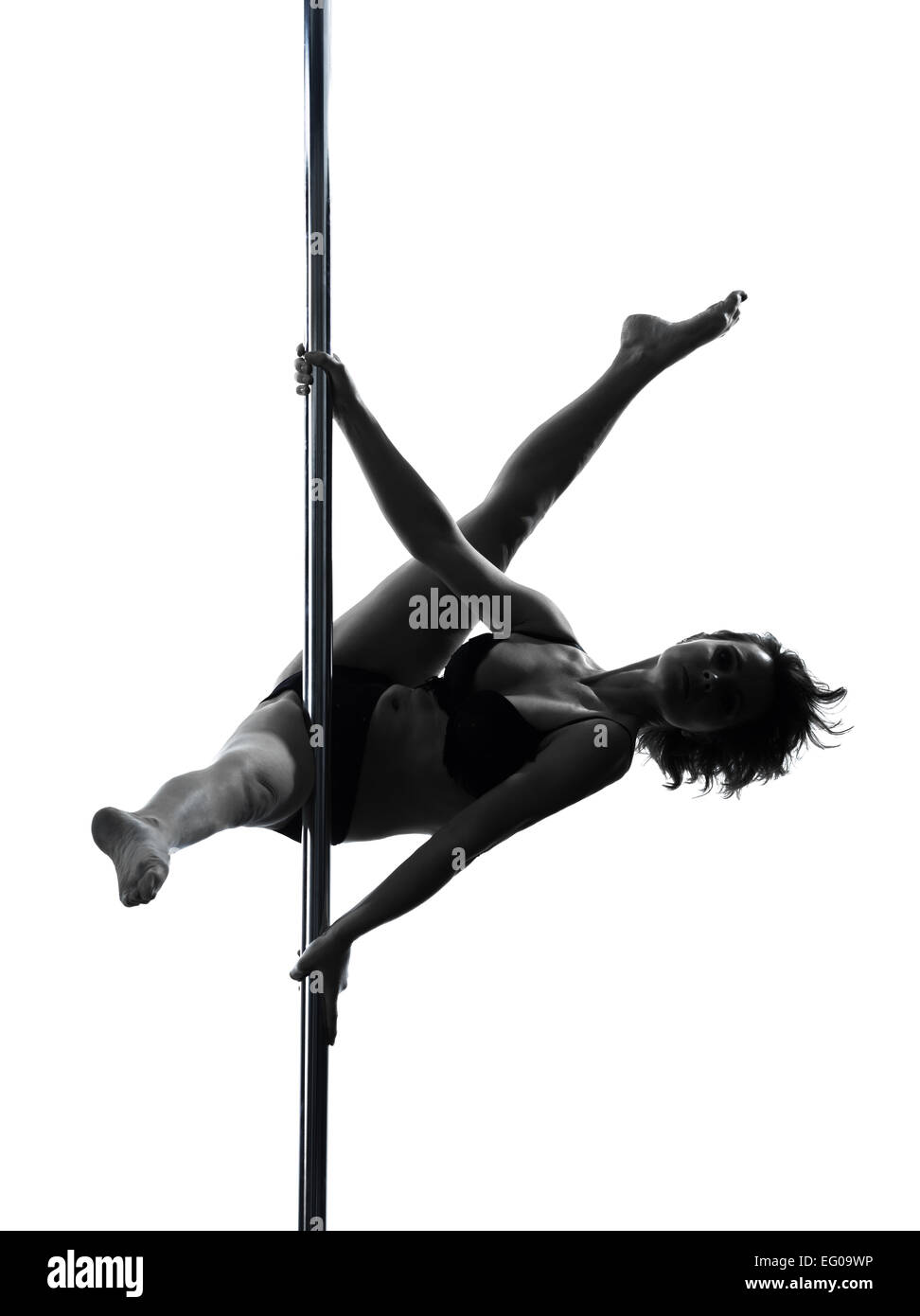 Una donna pole dancer dancing in silhouette studio isolato su sfondo bianco Foto Stock