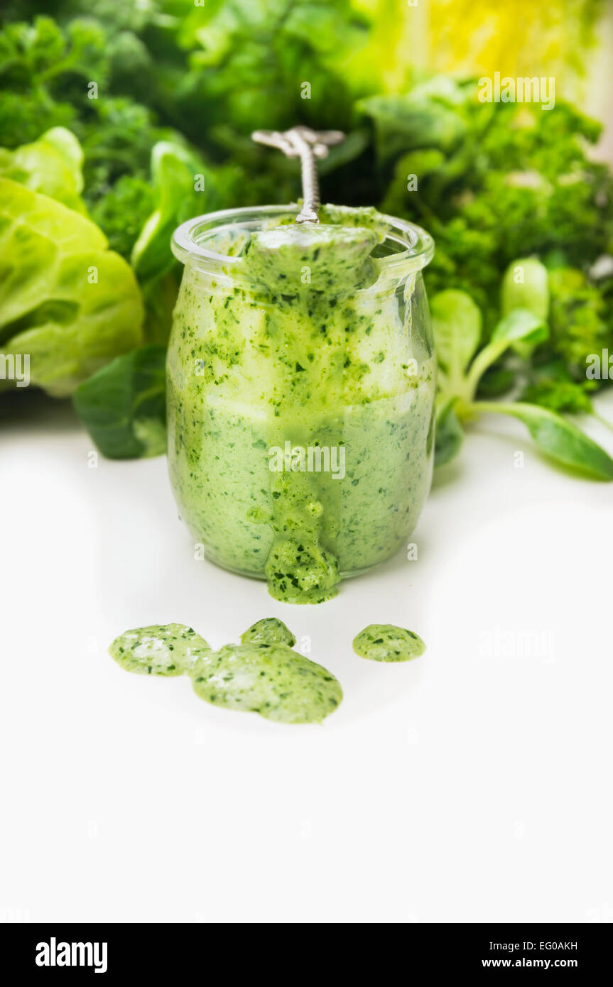 Frullato di verde in un barattolo di vetro e cucchiaio con ingredienti Foto Stock