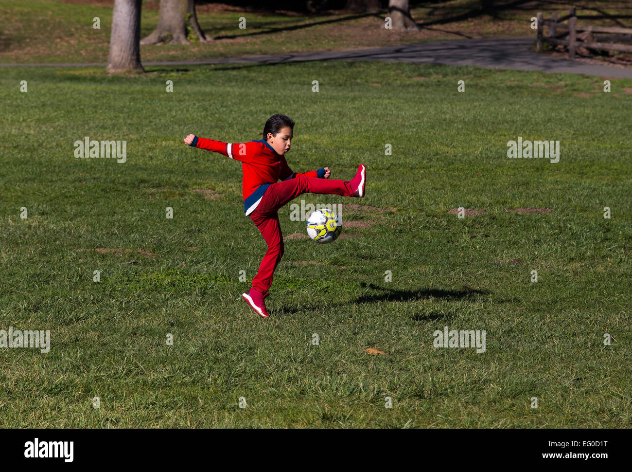 Giovane ragazzo ispanica di imparare a giocare a calcio da calci palla calcio mentre giocano a calcio in Pioneer Park nella città di Novato California Foto Stock