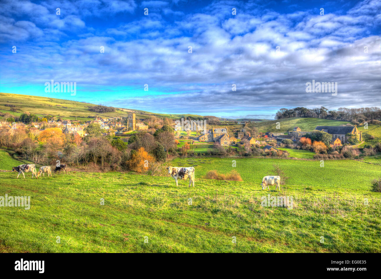 Villaggio Inglese di Abbotsbury Dorset UK impostato in campagna con le mucche e una chiesa come un dipinto in vividi colori luminosi HDR Foto Stock