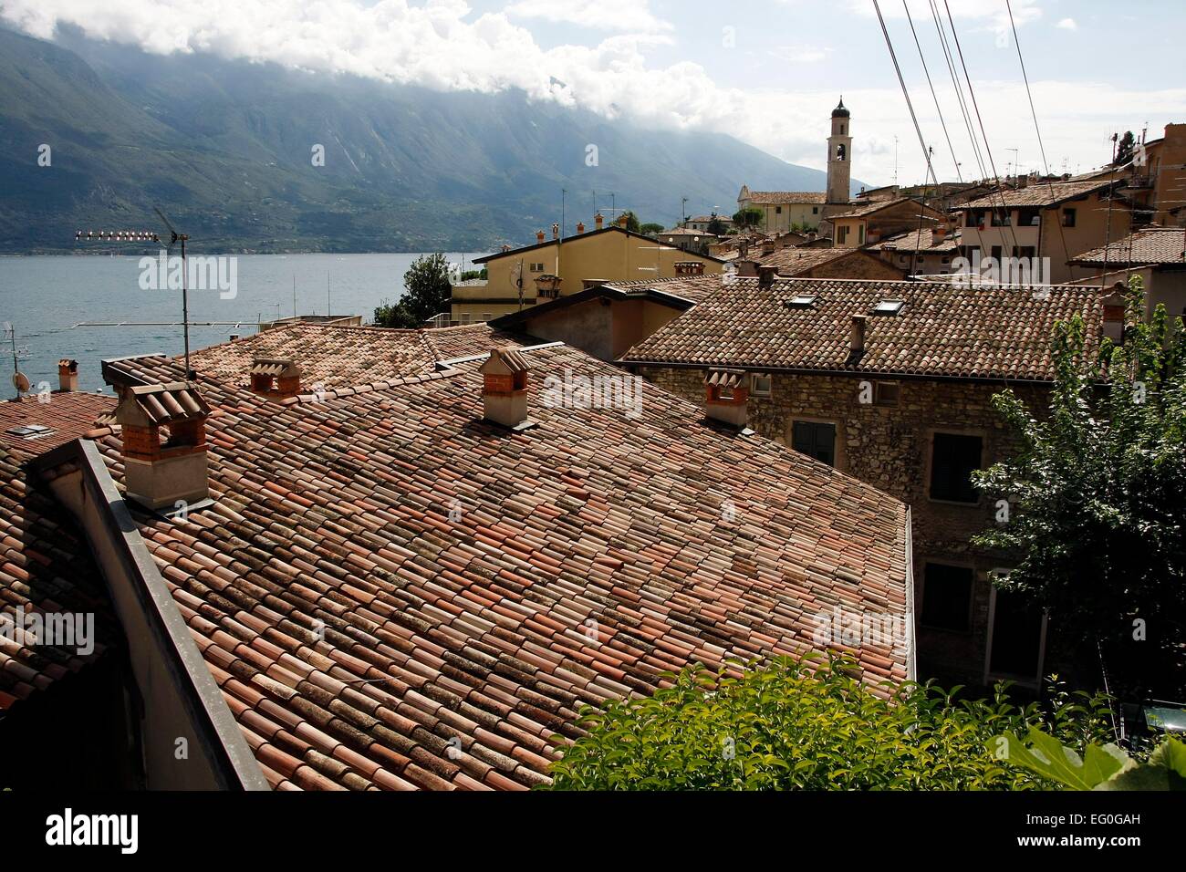 Vista sui tetti di Limone sul riparo e il Lago di Garda. Ai piedi di un ripido pendio a monte dell'affascinante cittadina di Limone del Sul è costruito in terrazze. Lombardia, Italia. Foto: Klaus Nowottnick Data: Agosto 28, 2014 Foto Stock