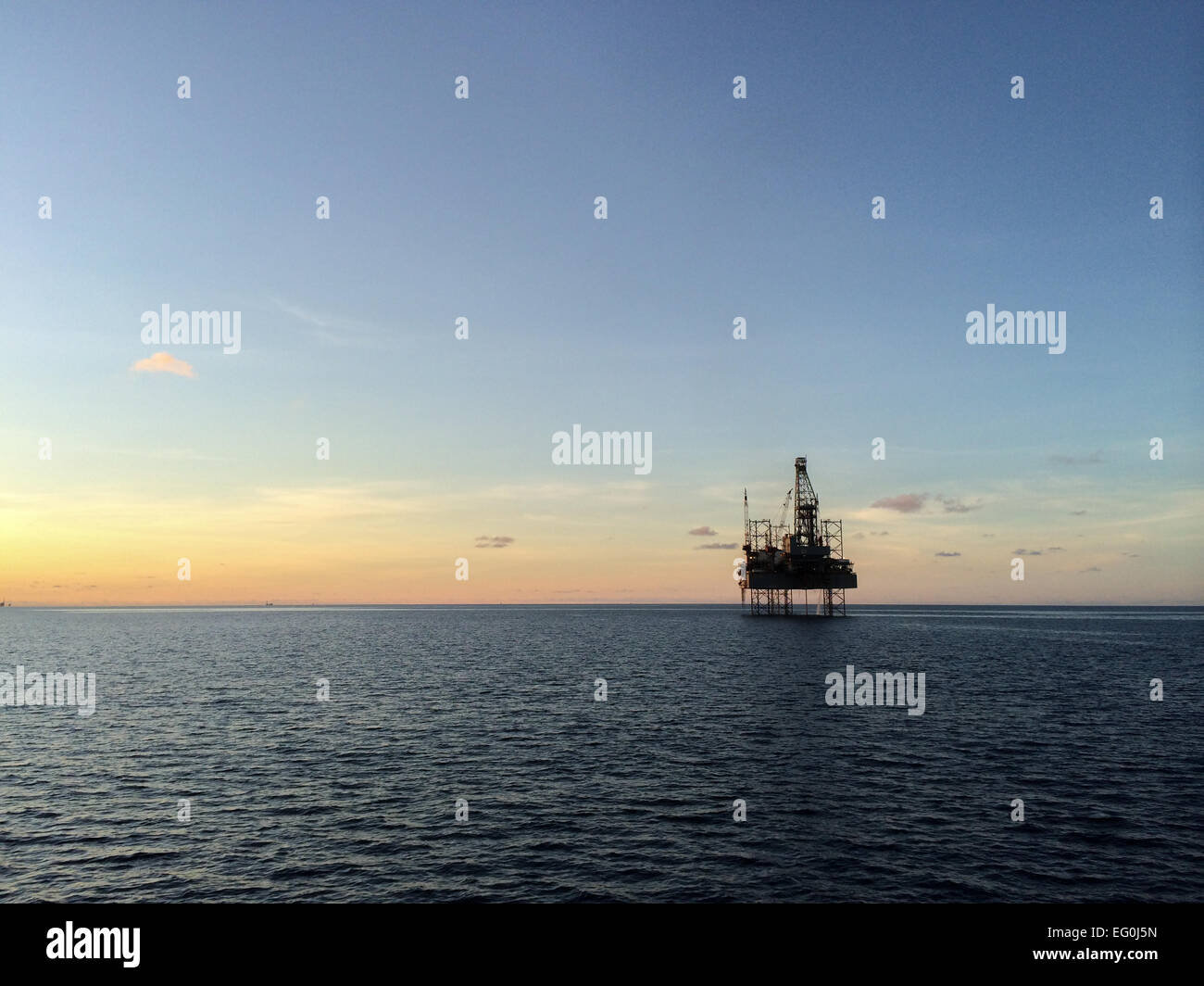 Silhouette di una piattaforma offshore durante il tramonto Foto Stock