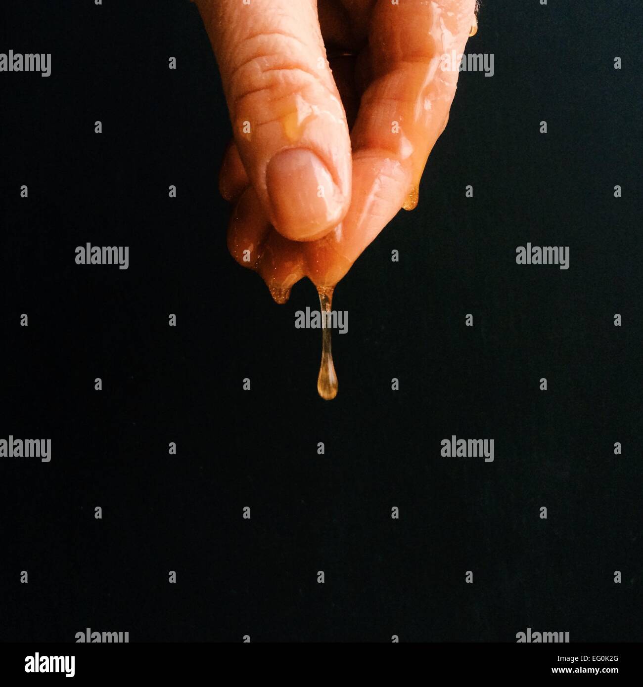 Gocciolamento di mano con miele Foto Stock