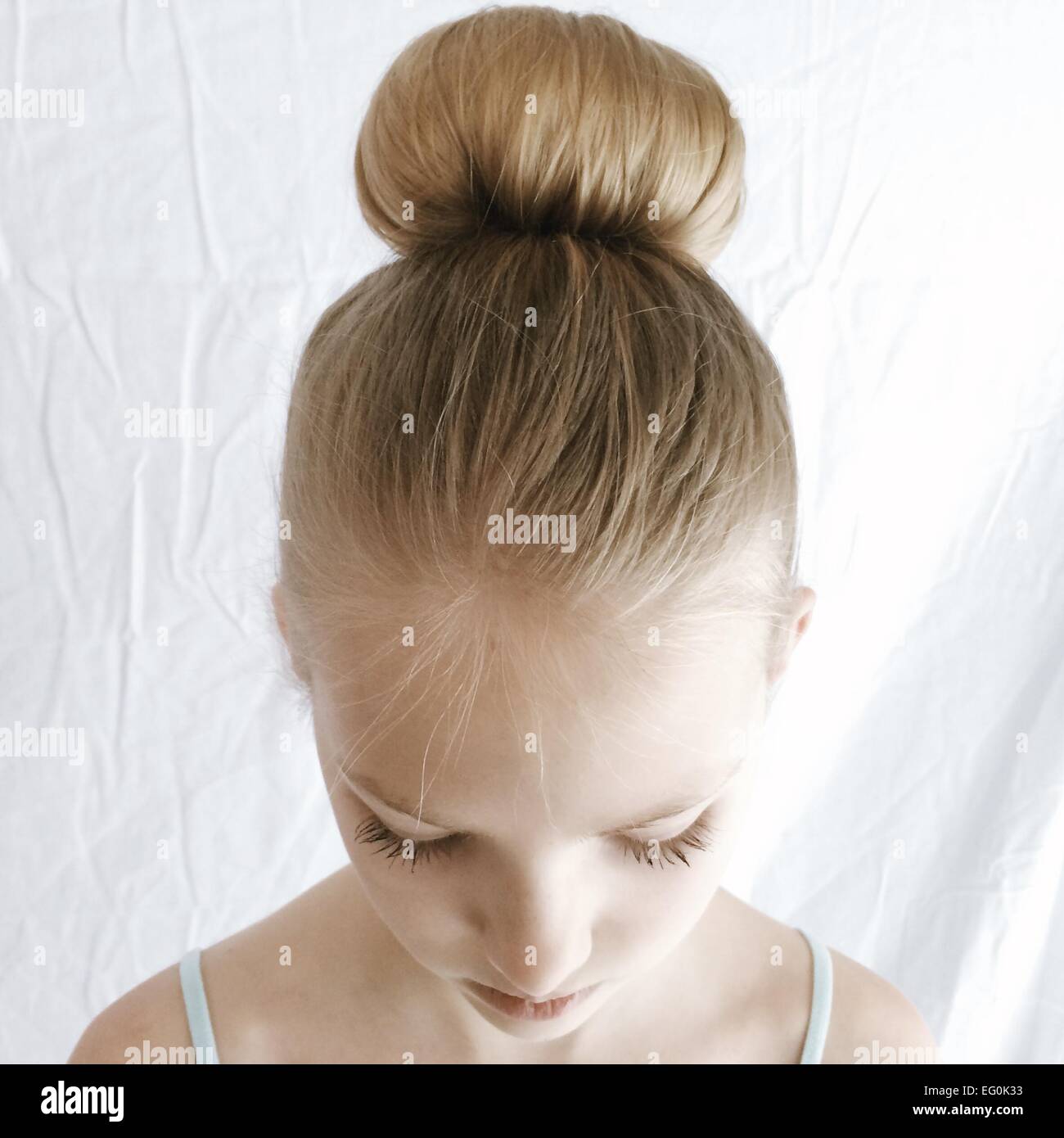 Ritratto di una ragazza con un capello bun guardando verso il basso Foto Stock