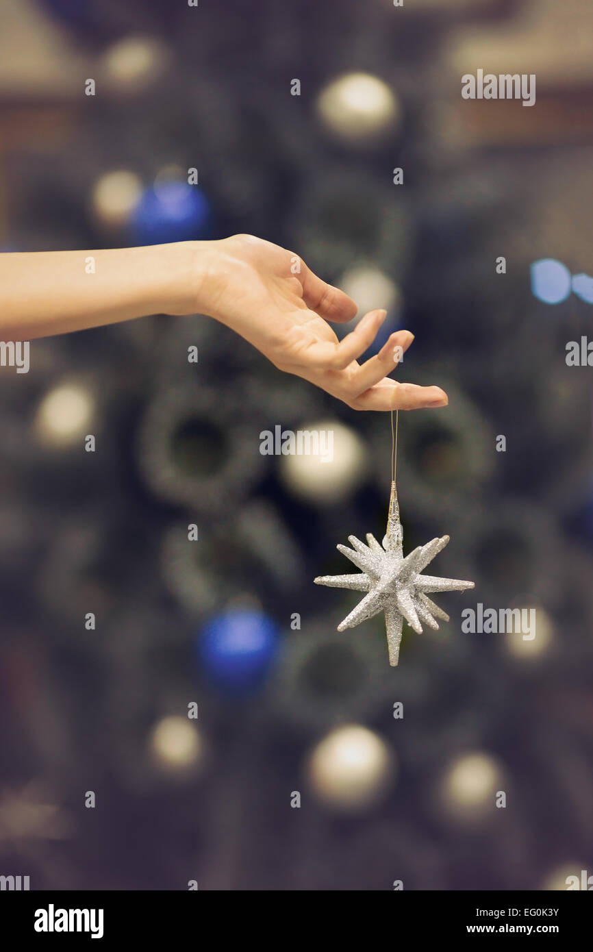 Argento stella di Natale contro sfocato albero di Natale decorato Foto Stock