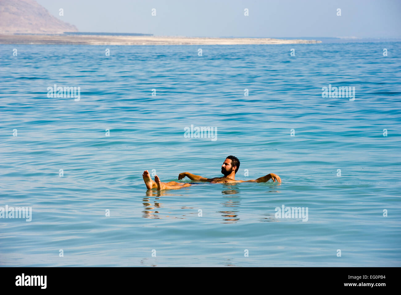 Mar Morto; Israele - 16 ottobre, 2014: un uomo galleggiante in acqua salata del Mar Morto in Israele Foto Stock