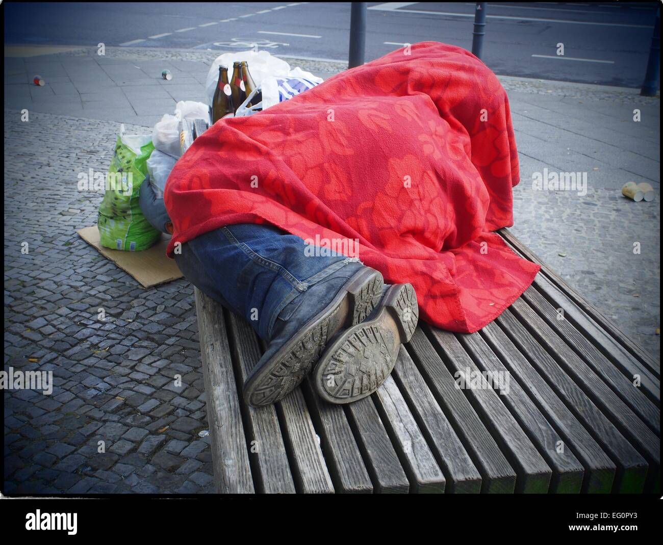 Un senzatetto ubriachi giacente su un banco in una strada di Berlino, 29 giugno 2014. Foto: Wolfram Steinberg/dpa Foto Stock