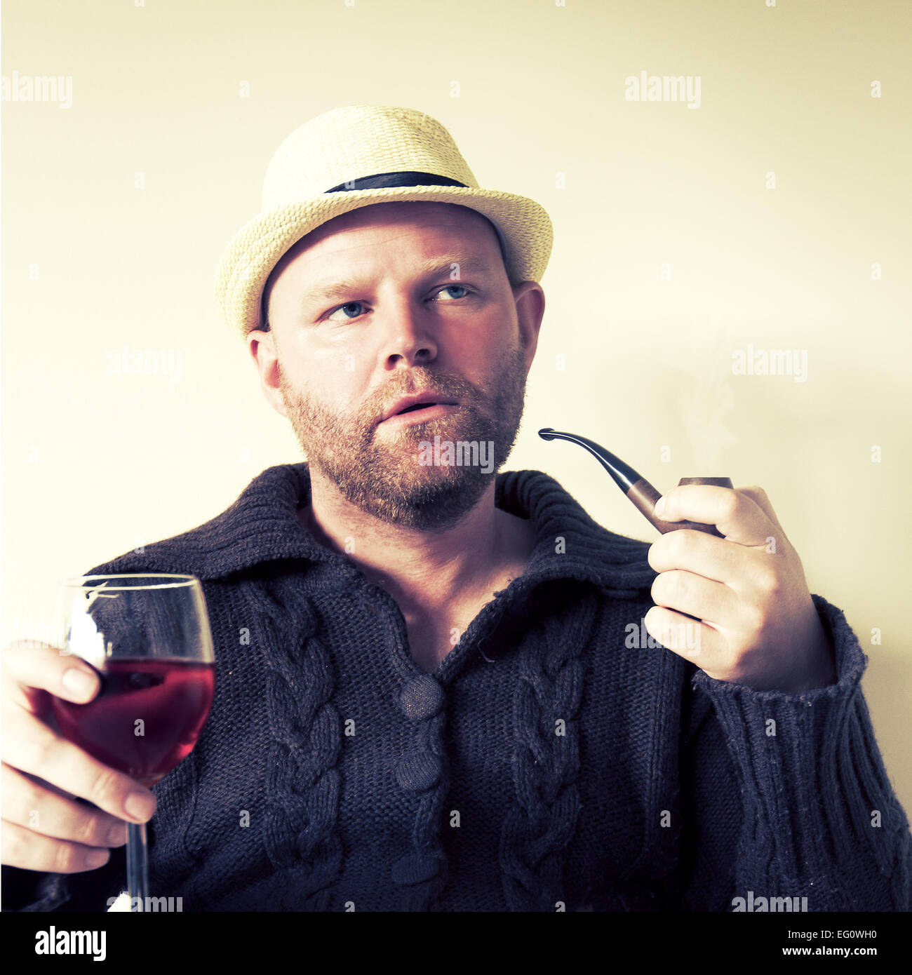 Un uomo con la tubazione e il vino. Foto Stock