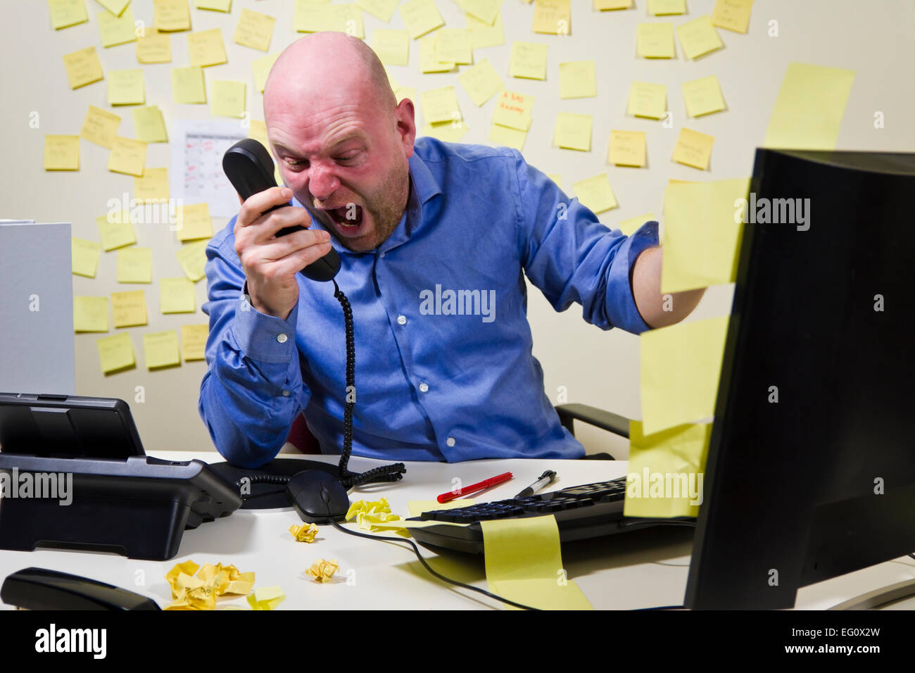 Arrabbiato boss / uomo urlando al telefono nel suo ufficio. Foto Stock