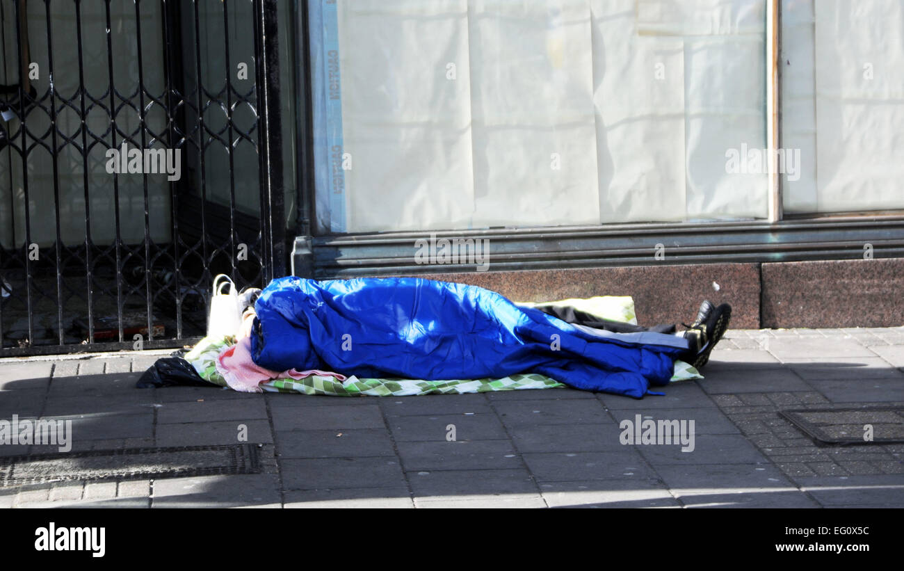 Brighton UK - senzatetto che dorme in modo approssimativo sulle strade di Brighton in un sacco a pelo Foto Stock
