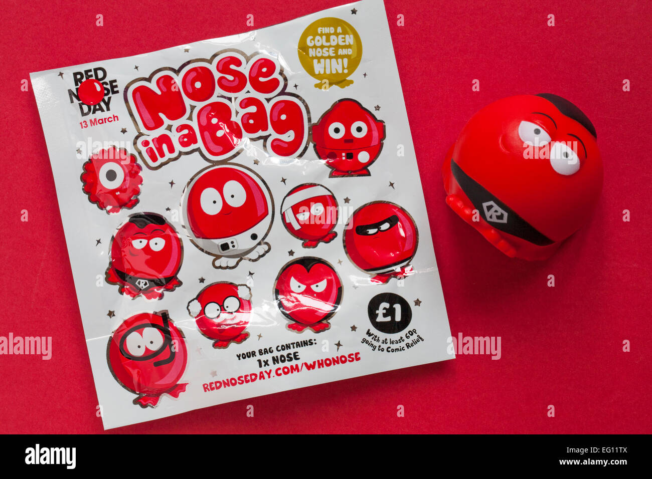 Naso in un sacchetto di trovare un naso d'oro e vincere pronto per il Red Nose Day il 13 marzo con Supernose naso rosso su sfondo rosso Foto Stock