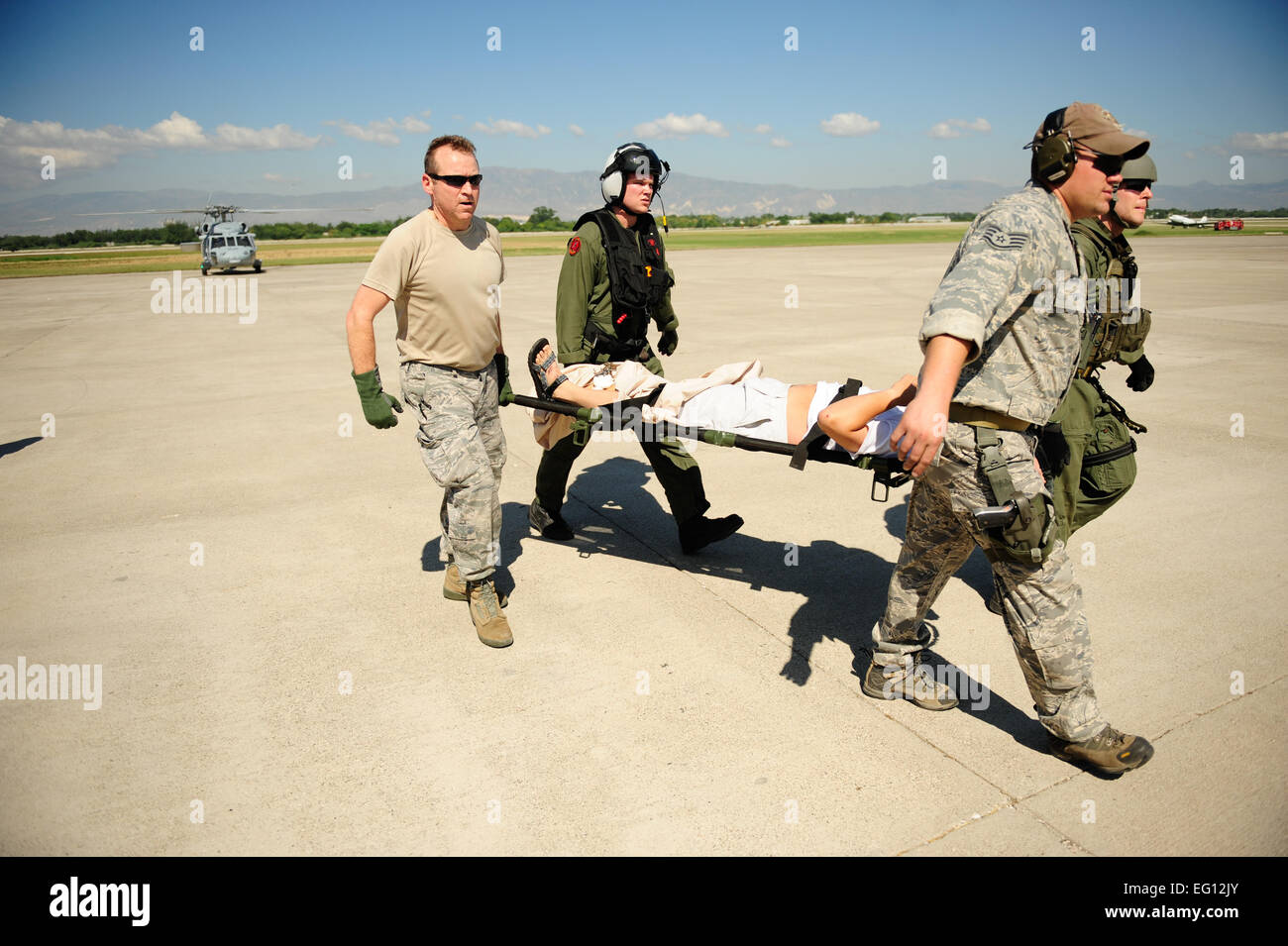 Stati Uniti Air Force e il personale della Marina trasportare un ferito a Haiti un incidente punto di raccolta a Port-Au-Prince aeroporto 15 gennaio 2010. Dipartimento della difesa sono stati spediti ad Haiti per aiutare con aiuti umanitari e di soccorso in caso di catastrofe dopo una grandezza 7 terremoto che ha colpito il paese il 12 gennaio 2010. Stati Uniti Air Force foto di Tech. Sgt. James L. Harper Jr., U.S. Air Force. Rilasciato Foto Stock