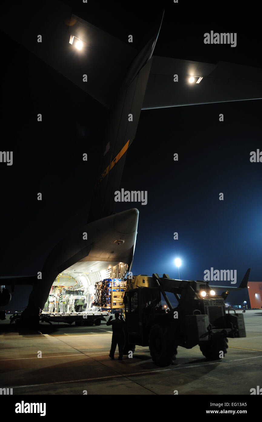 Stati Uniti I soldati dell esercito dal 688th rapida apertura porta elemento, Fort Eustis, Virginia, carico e carico di forniture di soccorso su un U.S. Air Force Reserve C-17 Globemaster III gli aeromobili a sostegno del terremoto ad Haiti soccorsi a Langley Air Force Base, Va., gen. 16, 2010. Il C-17 equipaggio dal 729th Airlift Squadron, marzo riserva d'aria di base, California, prendendo parte nel funzionamento risposta unitaria. Il personale Sgt. Giacobbe N. Bailey Foto Stock