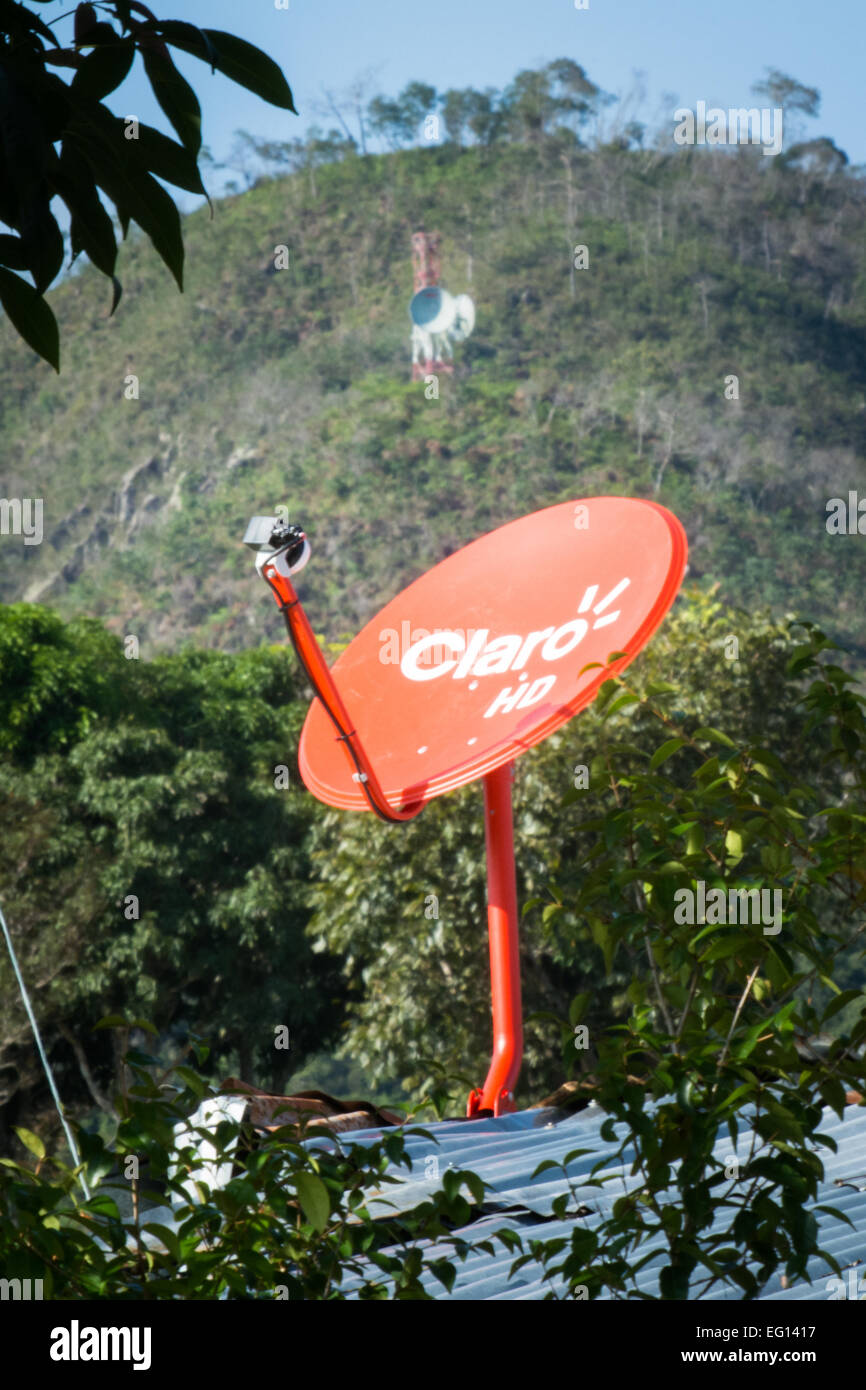 Una parabola satellitare sul tetto e la torre delle comunicazioni su pendio Foto Stock
