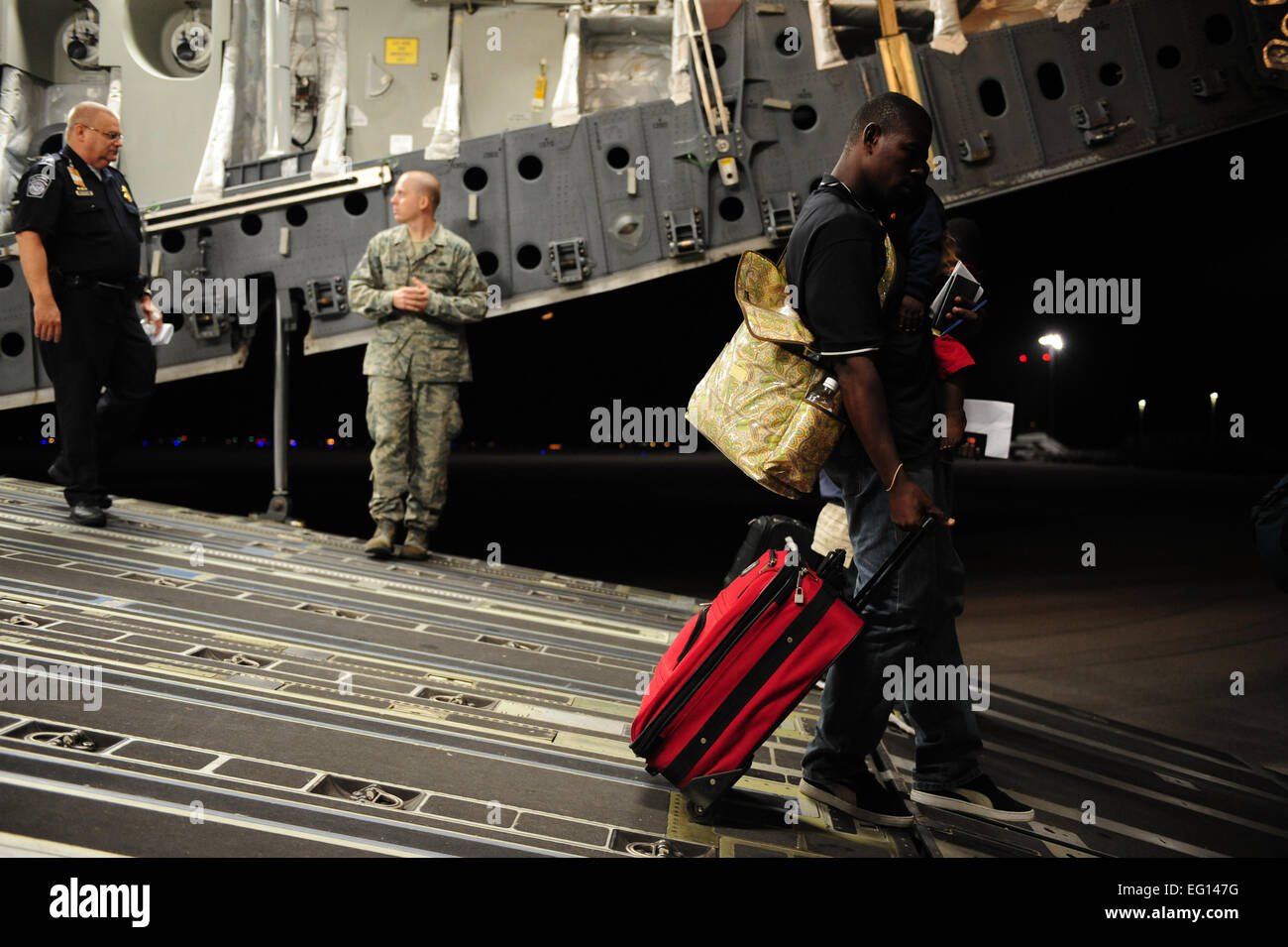 Una C-17 Globemaster III aeromobile dal 452nd Aria Mobilità ala, marzo riserva d'aria di base, California, offload americano haitiani sfollati a Orlando Sanford International Airport, Fla., Gennaio 18, 2010. Il C-17 equipaggio è assegnato al il 729th Airlift Squadron, marzo ARB, Calif. Il personale Sgt. Giacobbe N. Bailey / Non rivisto Foto Stock