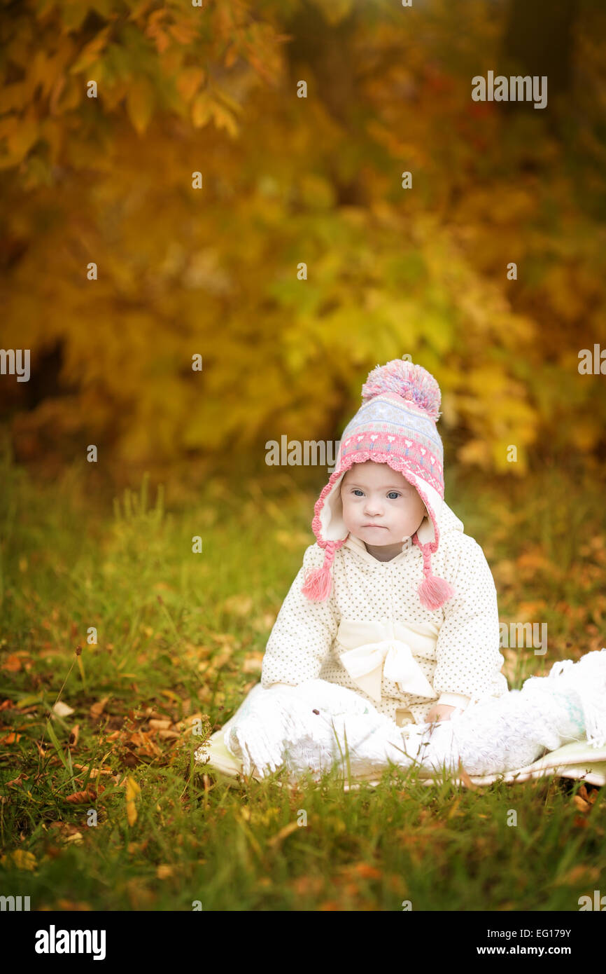 La ragazza con la sindrome di Down è a riposo in autunno park Foto Stock