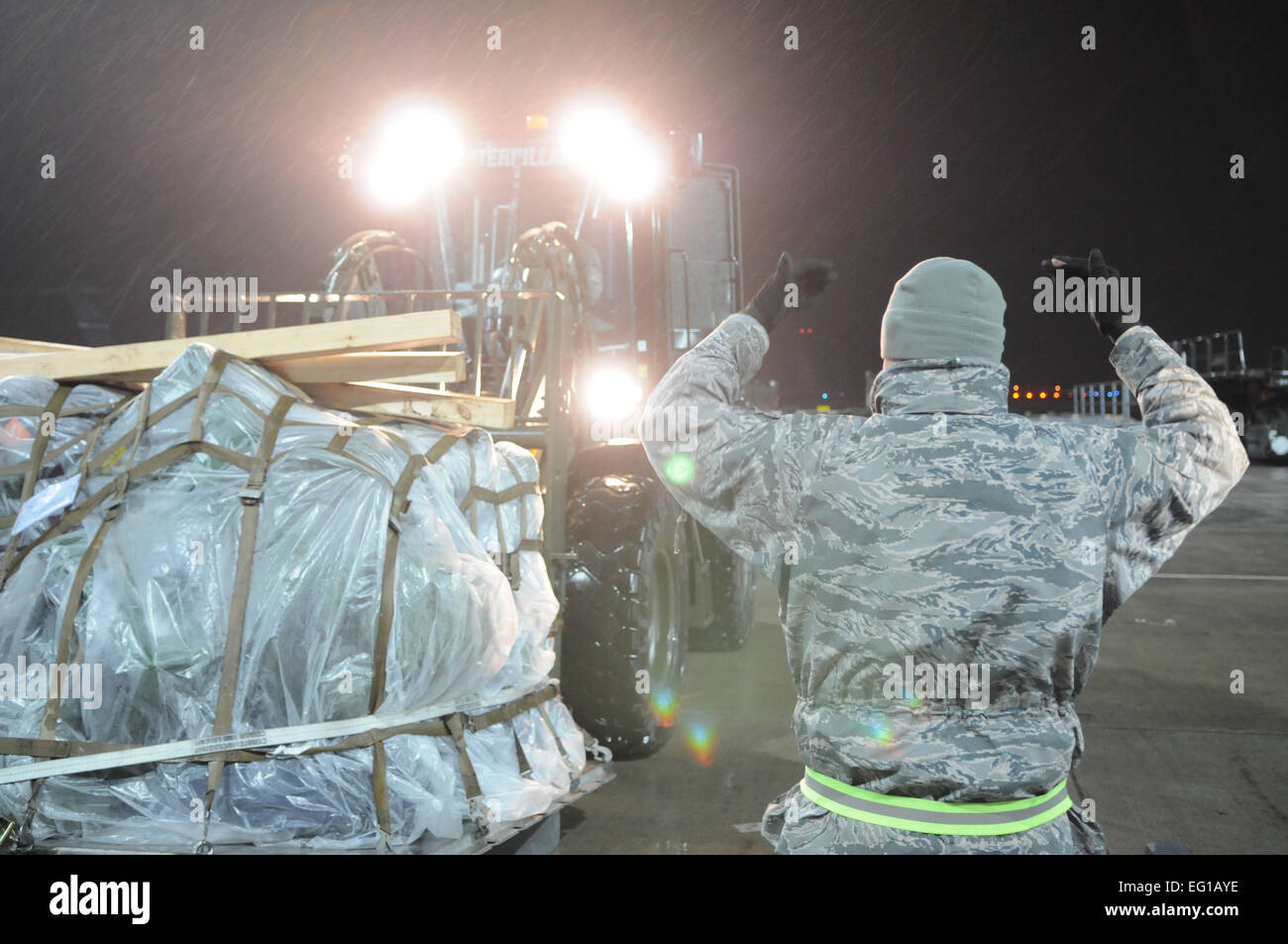 A noi. Air Force Airman assegnato al 52nd logistica squadrone Readiness guide un altro Airman durante la movimentazione di pallet su una scala per essere pesato a Spangdahlem Air Base, Germania, 19 marzo 2011, in preparazione per la spedizione nel supporto Joint Task Force JTF Odyssey Dawn. JTF Odyssey Dawn è la U.S. Africa il comando task force istituita per fornire comando operativo e tattico e di controllo le forze militari USA a sostegno della risposta internazionale per i disordini in Libia e in applicazione della risoluzione del Consiglio di Sicurezza delle Nazioni Unite della risoluzione UNSCR 1973. La UNSCR 1973 autorizza tutte le misure necessarie per pro Foto Stock