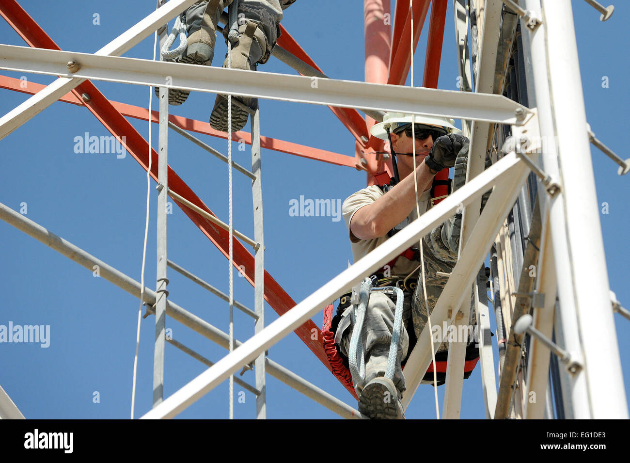 Stati Uniti Air Force aviatori 1a classe Steve Lippitt e Remo Stewart, sia tecnici con il 447th comunicazioni Expeditionary Squadron, fissare il cavo per supporti di metallo di un 140 piedi di torre dopo l'installazione di una delle forze americane antenna rete Agosto 25, 2011, a Sather Air Base, Iraq. L'antenna fornirà un segnale per gli Stati Uniti servicemembers, civili e gli appaltatori che restano nella zona come le operazioni di stiratura continua. Il personale Sgt. Mike Meares Foto Stock