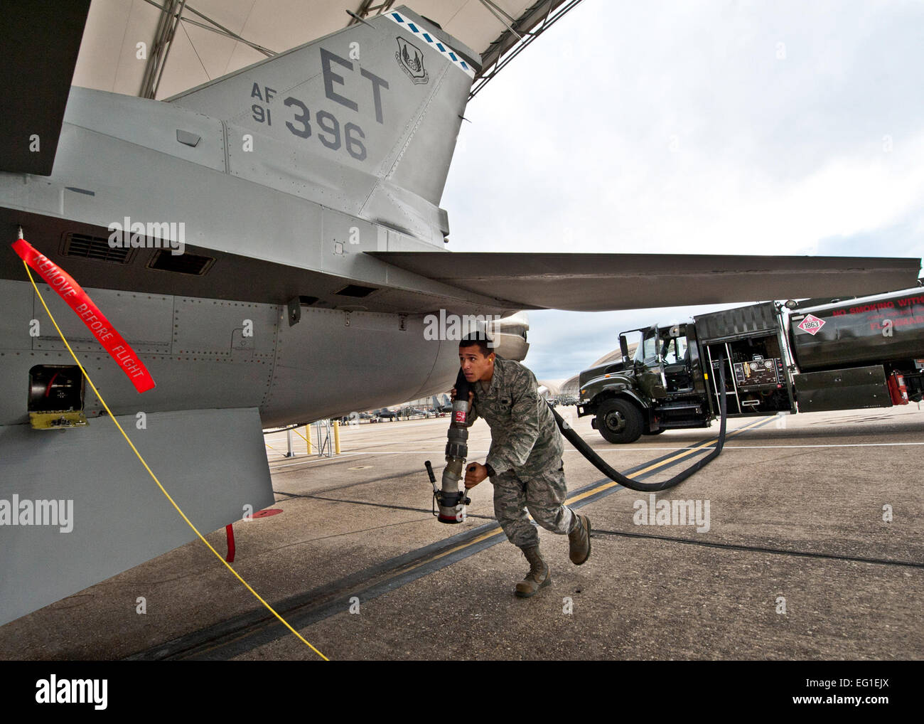 Stati Uniti Air Force Airman Jonathan Quinchia trascina un flessibile carburante nov. 28, 2011, per rifornire un U.S. Air Force F-16 Fighting Falcon fighter aircraft con la quarantaseiesima ala prova a Eglin Air Force Base, Fla. lo scorso anno, più di 14 milioni di galloni di carburante e triogenia i prodotti sono stati consegnati a soddisfare i 8.000 test e missioni di formazione sulla base. Quinchia è assegnato per la 96disponibilità logistica Squadron. Samuel King Jr. Foto Stock
