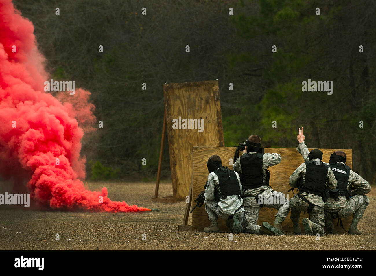 Stati Uniti Air Force aviatori prendere la copertura dietro un muro durante un "Shoot, spostare comunicare" Corso di formazione di Febbraio 16, 2012, a base comune, Charleston S.C. Il training insegna aviatori di reagire ad un tiratore ostile con coperchio e una comunicazione efficace per la manovra e innestare il bersaglio. Airman 1. Classe George Goslin Foto Stock